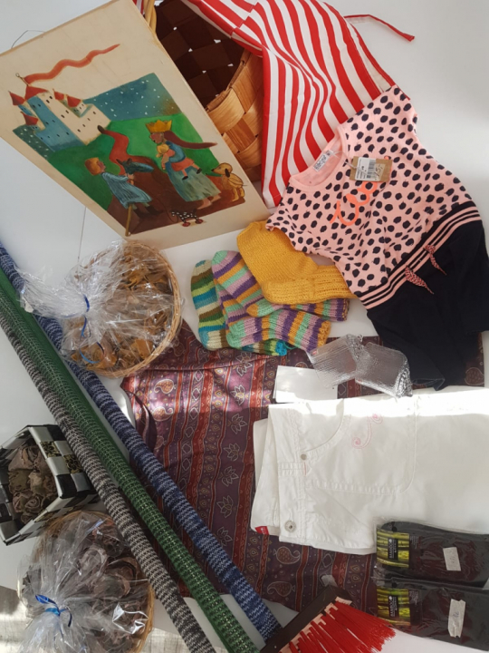 Kuvassa villasukkia, sytykeruusuja, taulu, essu ym. myyjäisissä myytävää