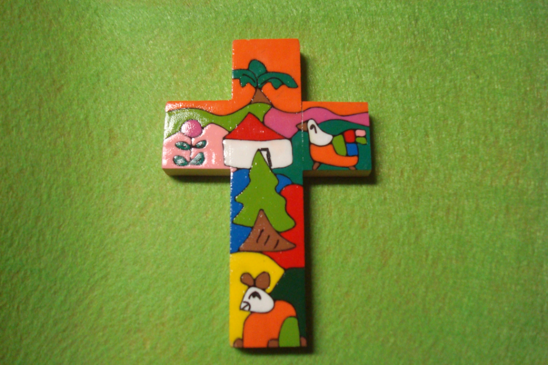 Iloisen värinen risti vihreän kankaan päällä