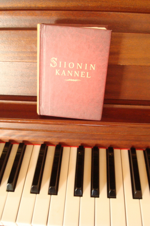 Evankelisen liikkeen laulukirja Siionin Kannel pianon nuottitelineellä