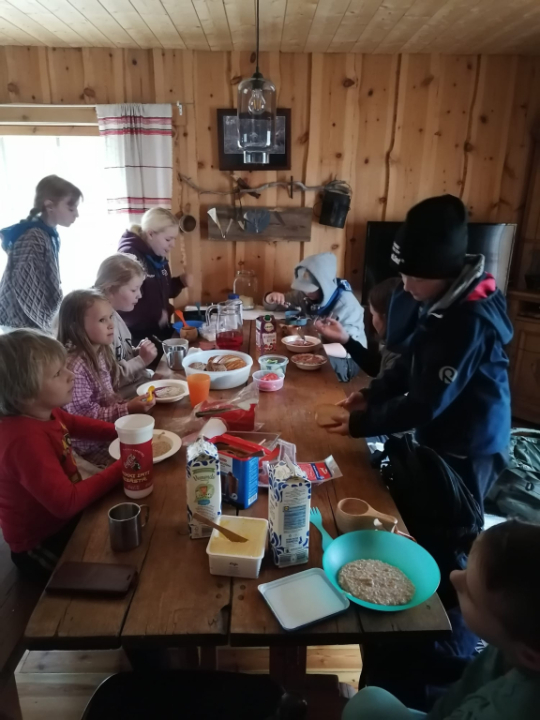 Lapset syövät aamupalaa pöydän ääressä.