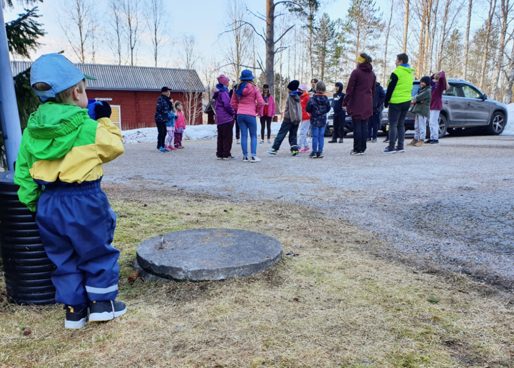 Pieni lapsi seuraa isompien lasten ponileikkiä.