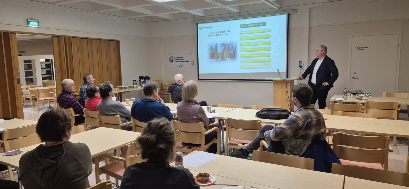 Kuvassa metsäkeskuksen asiantuntija pitämässä esitystä kuulijoille. 