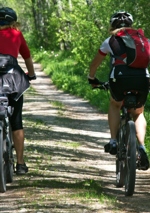 kaksi henkilöä ajaa pyörällä